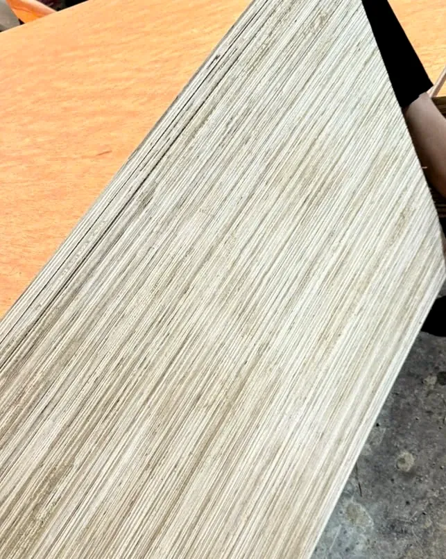 A bintangor plywood sheet edge seen at a diagonal, showing the cross-laid veneer layers of the stack