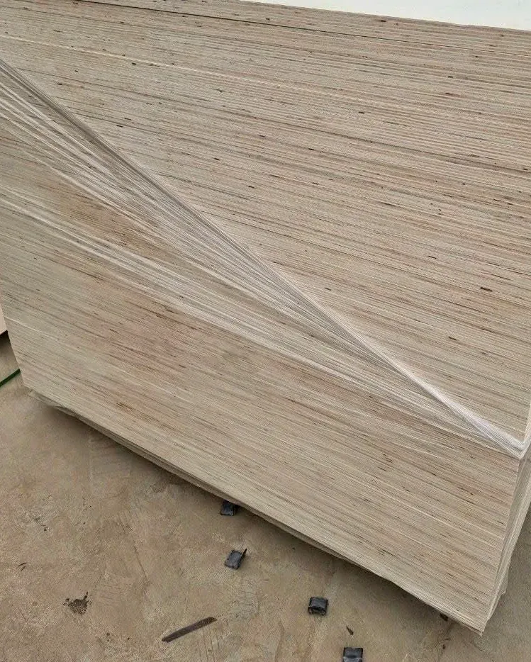 A strapped stack of pale poplar plywood sheets seen from the corner, ready for packing